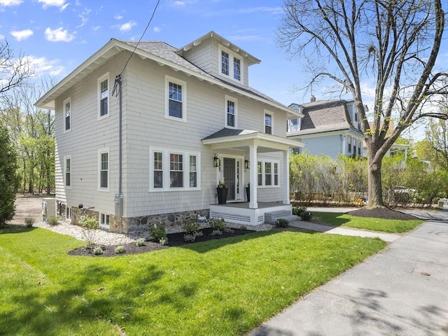 traditional style home featuring covered porch and a front yard