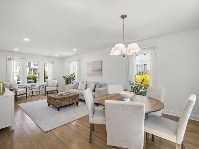 dining room with an inviting chandelier, recessed lighting, wood finished floors, and a wealth of natural light