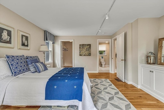 26 Sandy Meadow Way, Eastham, MA 02642 - bedroom with track lighting, light wood-style flooring, ensuite bathroom, and a walk in closet