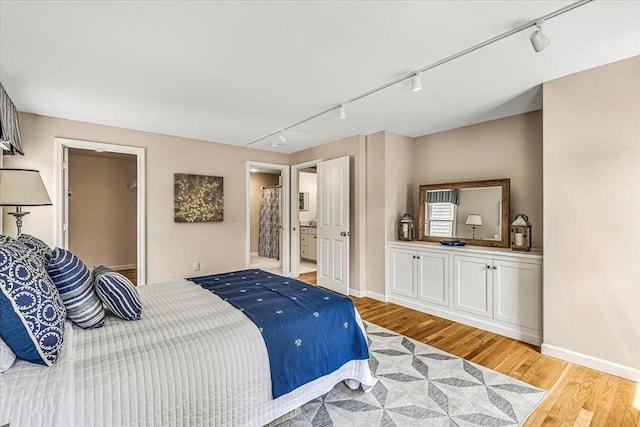 26 Sandy Meadow Way, Eastham, MA 02642 - bedroom with rail lighting, light wood-type flooring, and ensuite bath