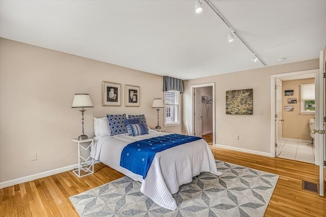 26 Sandy Meadow Way, Eastham, MA 02642 - bedroom with rail lighting, light wood-type flooring, a walk in closet, and a closet