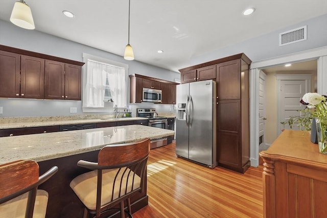 46 Converse Ave Unit 1, Malden, MA 02148 - kitchen with stainless steel appliances, a sink, pendant lighting, light wood-type flooring, and recessed lighting