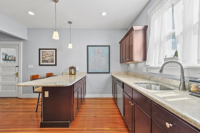 46 Converse Ave Unit 1, Malden, MA 02148 - kitchen featuring a sink, a peninsula, stainless steel dishwasher, a breakfast bar area, and baseboards