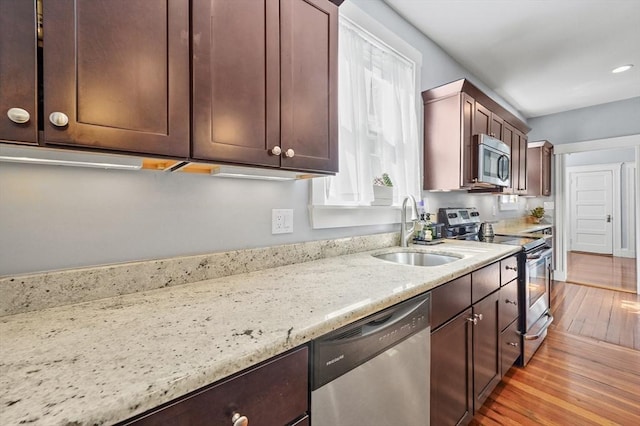 46 Converse Ave Unit 1, Malden, MA 02148 - kitchen with appliances with stainless steel finishes, a sink, light wood-style flooring, light stone counters, and recessed lighting