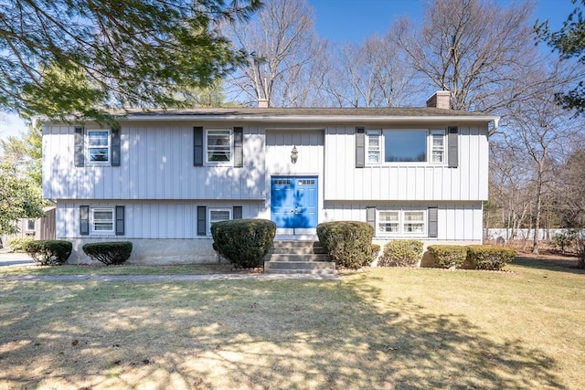 split foyer home featuring a front yard and a chimney