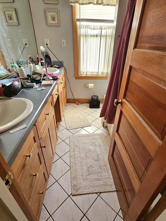 308 Hawthorn St, New Bedford, MA 02740 - bathroom featuring double vanity, tile patterned flooring, and baseboards
