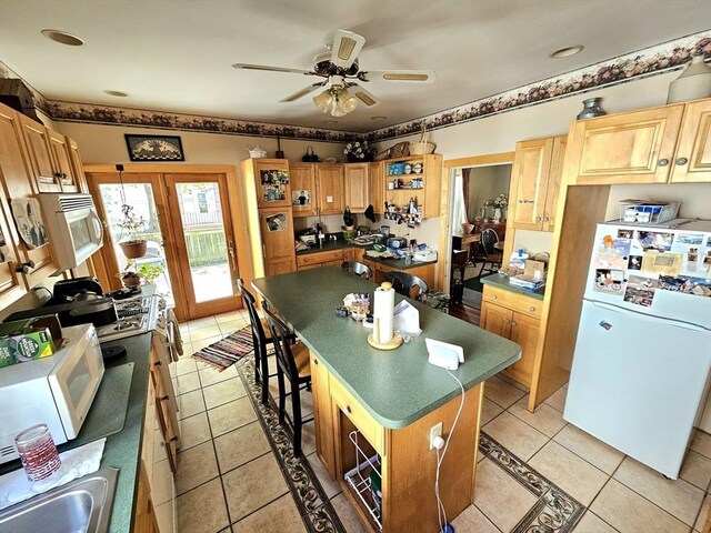 308 Hawthorn St, New Bedford, MA 02740 - kitchen with white appliances, a kitchen island, ceiling fan, and light tile patterned floors