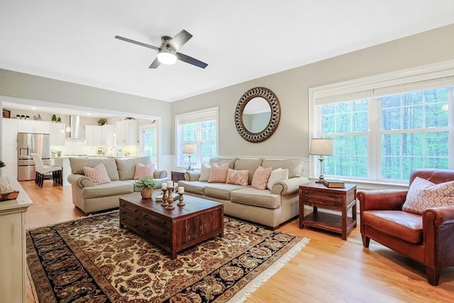 living room featuring light wood-style flooring and a ceiling fan