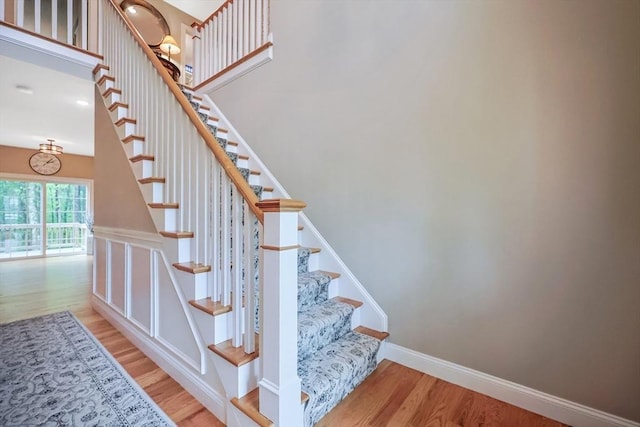 stairs featuring wood finished floors and baseboards