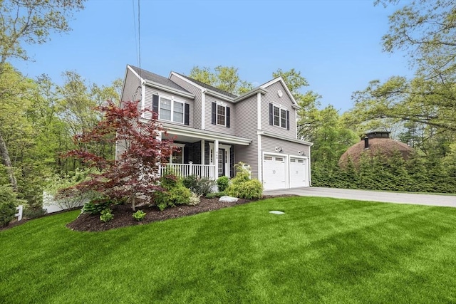 traditional home featuring covered porch, a garage, concrete driveway, and a front yard