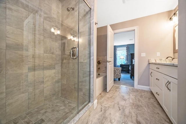 ensuite bathroom featuring a shower stall, vanity, and marble look tiles