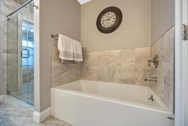 bathroom featuring a shower stall, a bath, and baseboards