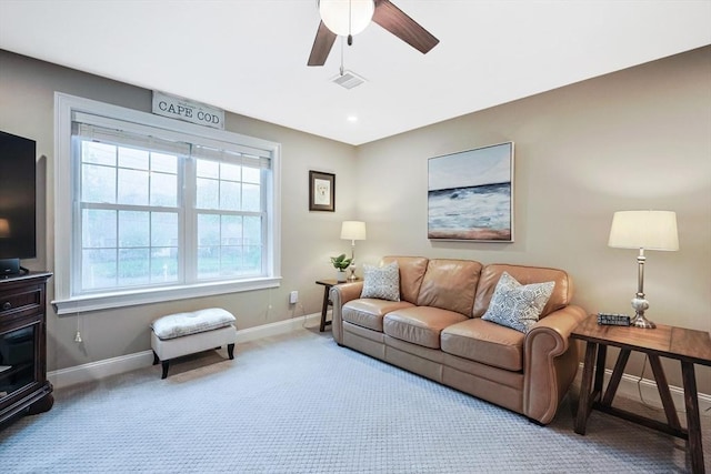 living room with baseboards, carpet flooring, and ceiling fan