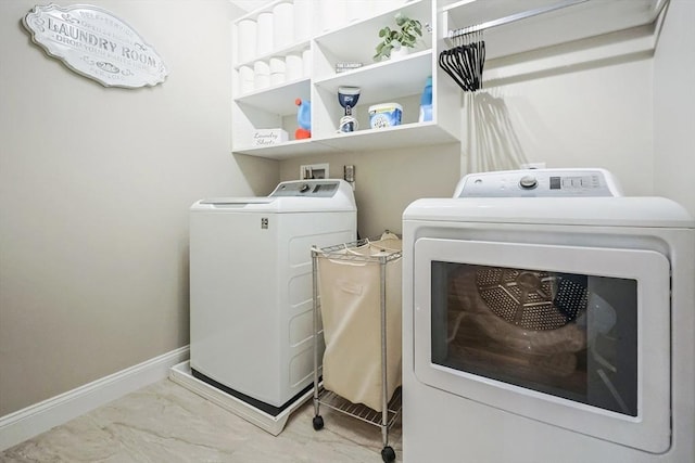 laundry room featuring washing machine and clothes dryer, marble look tile flooring, and baseboards