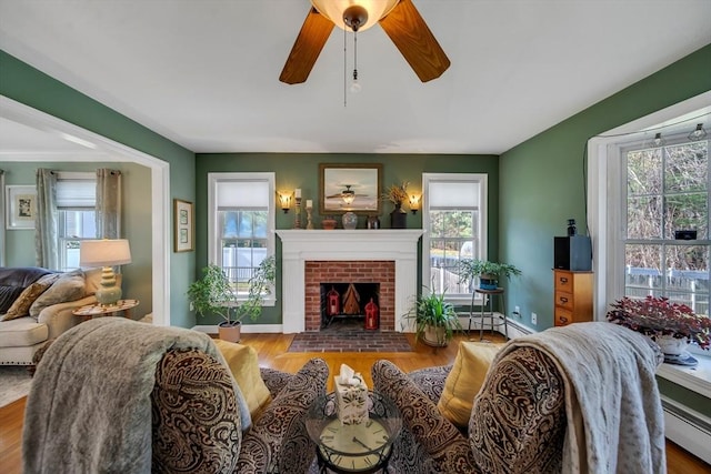 28 Sewall St, Shrewsbury, MA 01545 - living room with a ceiling fan, a brick fireplace, wood finished floors, and baseboard heating