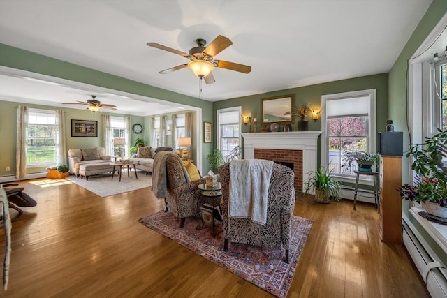 28 Sewall St, Shrewsbury, MA 01545 - living room with a baseboard radiator, hardwood / wood-style flooring, ceiling fan, a brick fireplace, and baseboard heating