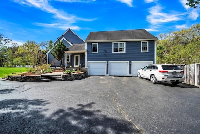 28 Sewall St, Shrewsbury, MA 01545 - split level home featuring an attached garage, asphalt driveway, and fence