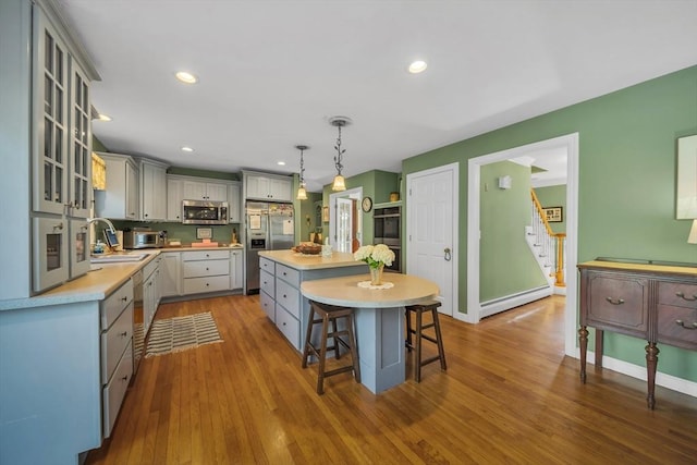 28 Sewall St, Shrewsbury, MA 01545 - kitchen with stainless steel appliances, gray cabinets, a sink, a kitchen island, and baseboard heating