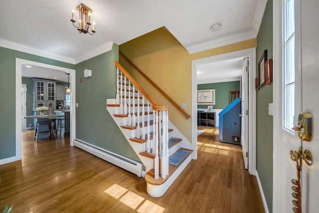 28 Sewall St, Shrewsbury, MA 01545 - stairs featuring a baseboard radiator, ornamental molding, wood finished floors, baseboards, and a chandelier