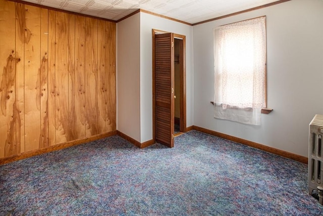 100 Weetamoe St, Fall River, MA 02720 - unfurnished bedroom featuring crown molding, carpet flooring, wooden walls, and a closet