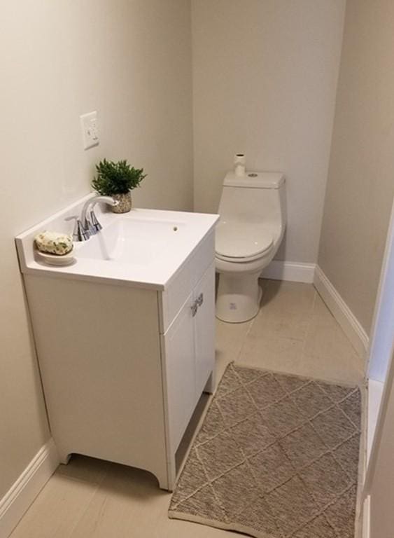 bathroom with tile flooring, toilet, and vanity