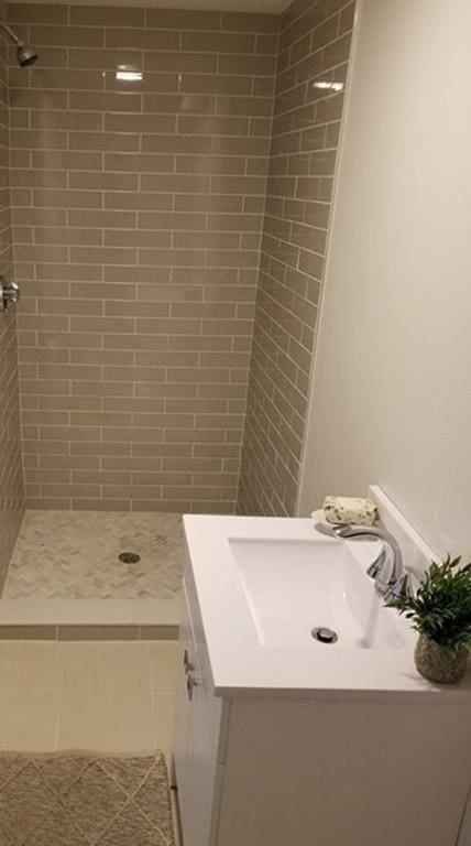 bathroom featuring vanity and tiled shower