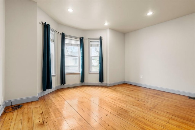unfurnished room featuring baseboards, light wood-style flooring, and recessed lighting
