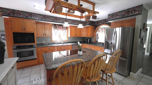 1820 Milk St, Dighton, MA 02715 - kitchen with black appliances, a sink, light tile patterned flooring, a center island, and brown cabinetry