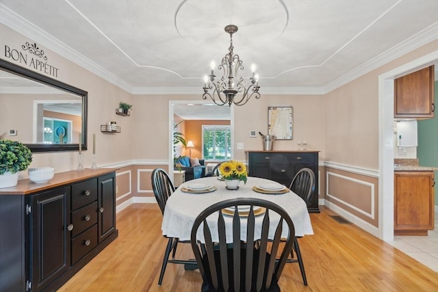 35 Michael Way Unit 29, Andover, MA 01810 - dining area featuring light wood-style flooring, a decorative wall, a chandelier, crown molding, and a wainscoted wall