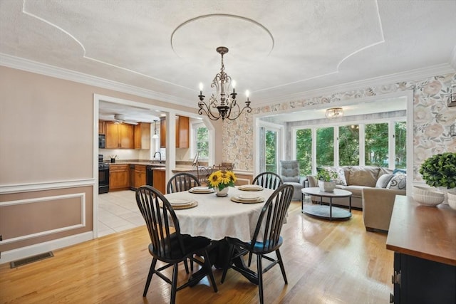35 Michael Way Unit 29, Andover, MA 01810 - dining space with ornamental molding, light wood-type flooring, a chandelier, a wainscoted wall, and a textured ceiling