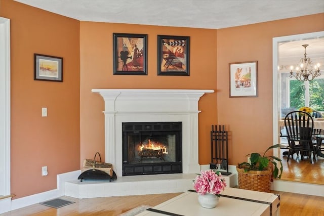 35 Michael Way Unit 29, Andover, MA 01810 - living room with wood finished floors, a chandelier, and a warm lit fireplace