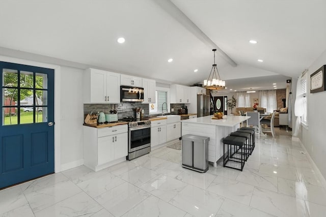 399 N Main St, Salem, NH 03079 - kitchen with stainless steel appliances, a breakfast bar area, a sink, baseboards, and recessed lighting