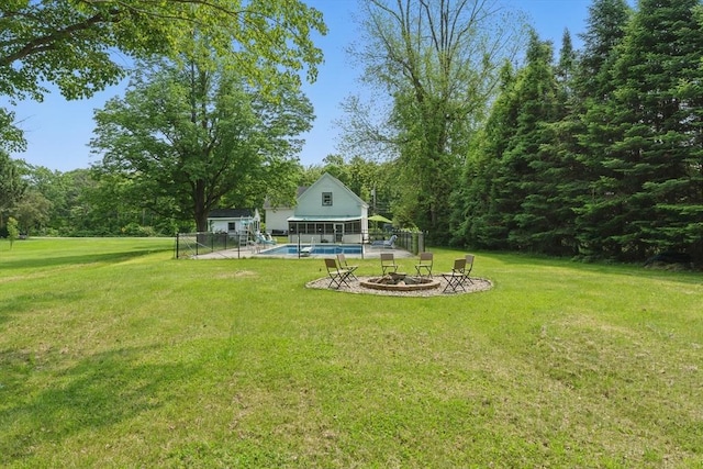 399 N Main St, Salem, NH 03079 - view of grassy yard featuring an outdoor pool, an outdoor fire pit, an outbuilding, a storage structure, and a patio