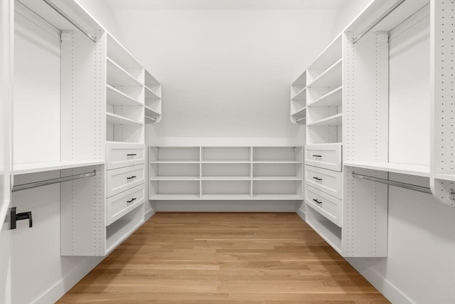 walk in closet with light hardwood / wood-style floors