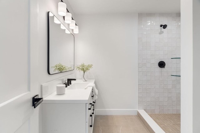 bathroom with tiled shower, vanity, and tile patterned floors