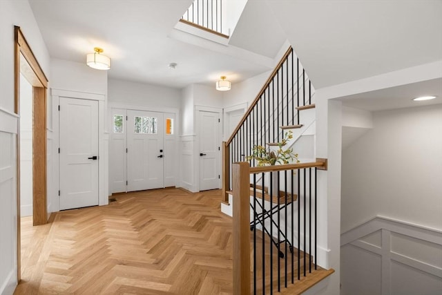 foyer entrance with a skylight and light parquet flooring