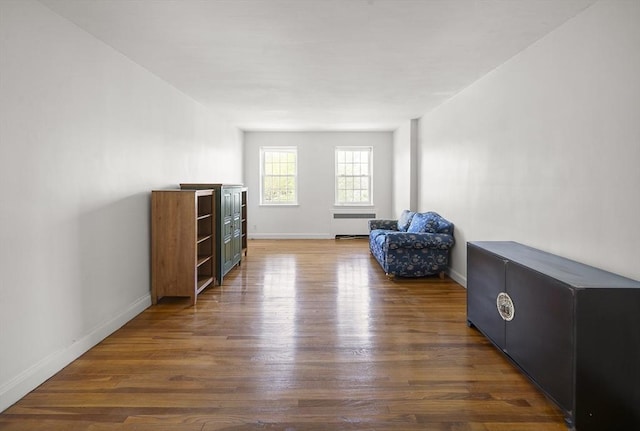 living area featuring radiator, baseboards, and wood finished floors
