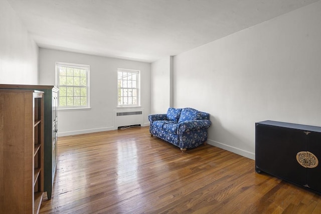 sitting room featuring radiator, baseboards, and wood finished floors