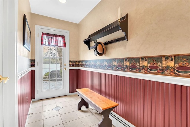 doorway featuring a wainscoted wall and light tile patterned flooring