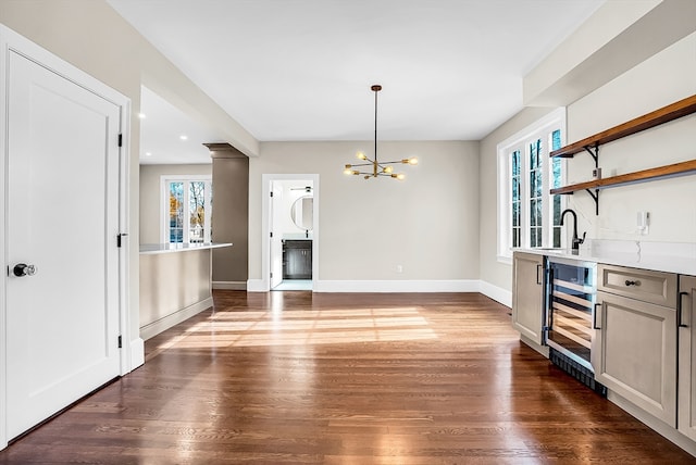 kitchen with a chandelier, dark hardwood / wood-style flooring, decorative light fixtures, and wine cooler