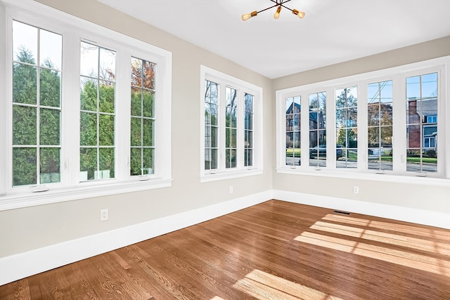 unfurnished sunroom featuring a notable chandelier