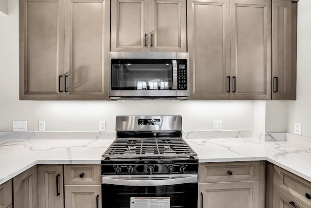 kitchen featuring light stone countertops and appliances with stainless steel finishes