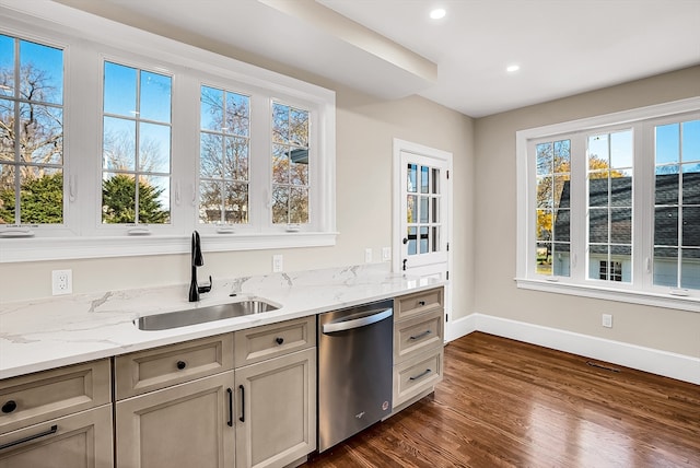 kitchen with stainless steel dishwasher, dark hardwood / wood-style floors, light stone countertops, and sink