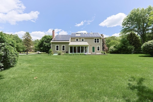 15 Amys Way, Franklin, MA 02038 - back of house featuring roof mounted solar panels, a chimney, and a lawn