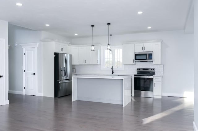 kitchen featuring tasteful backsplash, appliances with stainless steel finishes, light countertops, and dark wood-style flooring