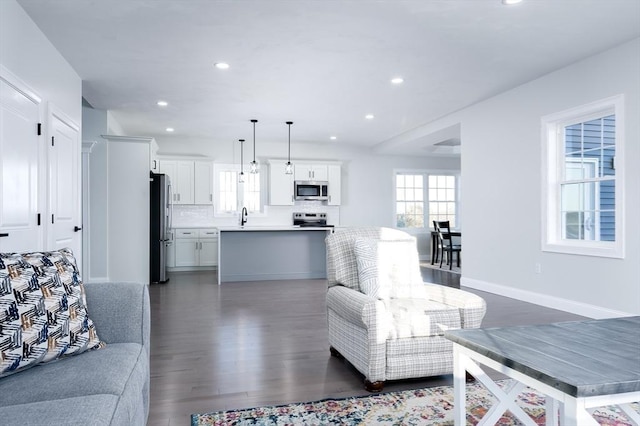 living area with dark wood-style floors, baseboards, and recessed lighting