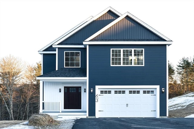 traditional home with board and batten siding, roof with shingles, driveway, and an attached garage