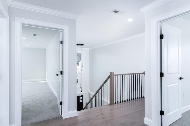 hall featuring visible vents, baseboards, an upstairs landing, and crown molding