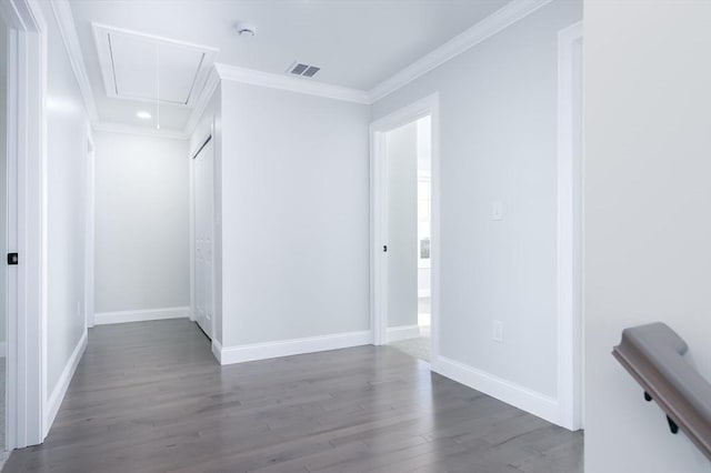 unfurnished room with dark wood-style floors, crown molding, visible vents, attic access, and baseboards