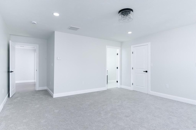 spare room with recessed lighting, visible vents, and baseboards